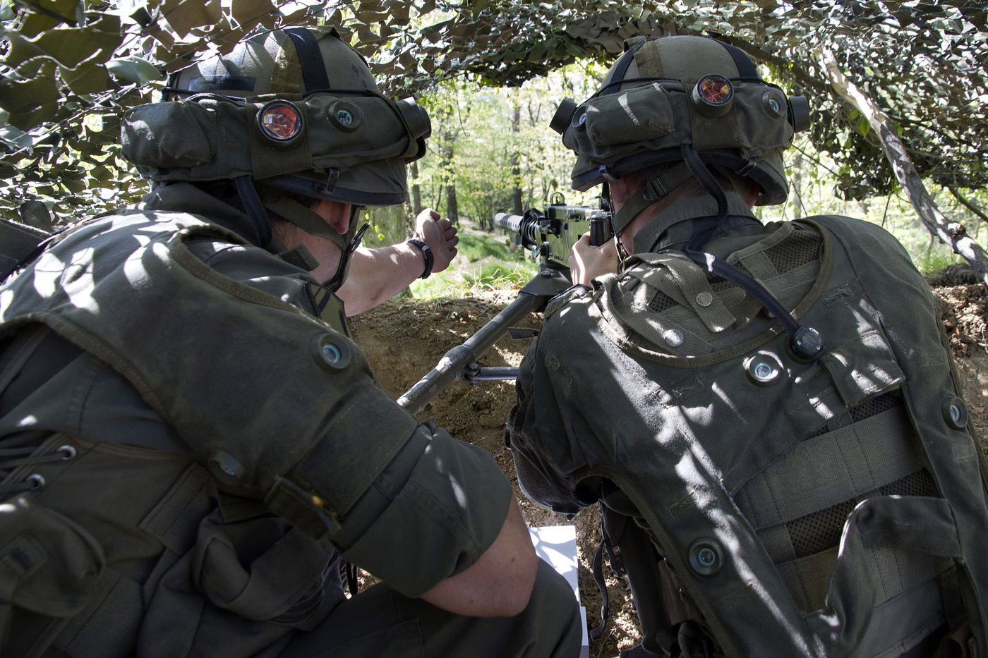 Zwei Soldaten an einem Maschinengewehr in gedeckter Stellung